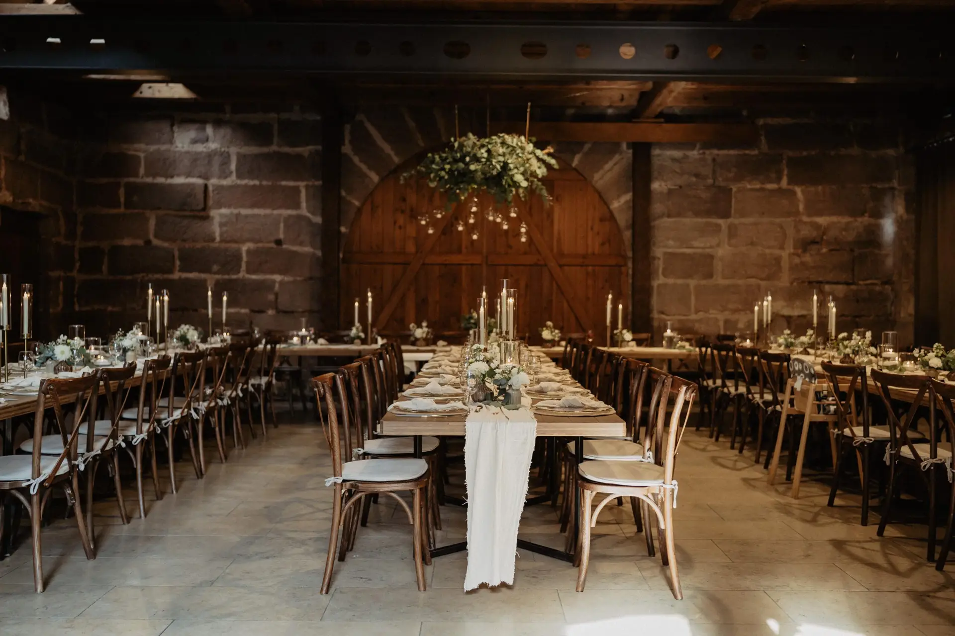 Elegante Hochzeitstafel in historischer Scheune mit Kerzenlicht
